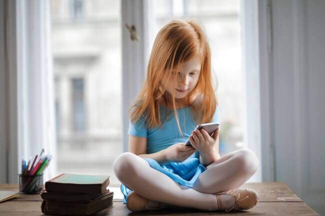 garota ruiva vendo apps para ver filmes no celular