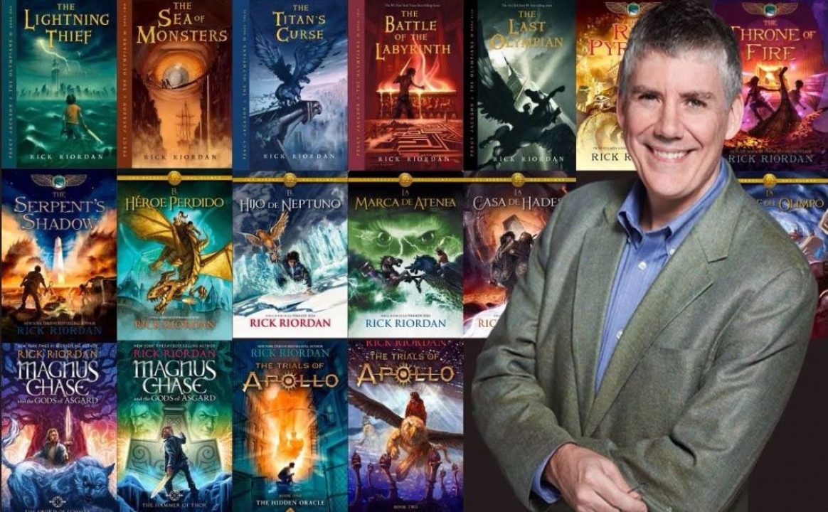 escritor rick riordan na frente dos livros percy jackson e os olimpianos